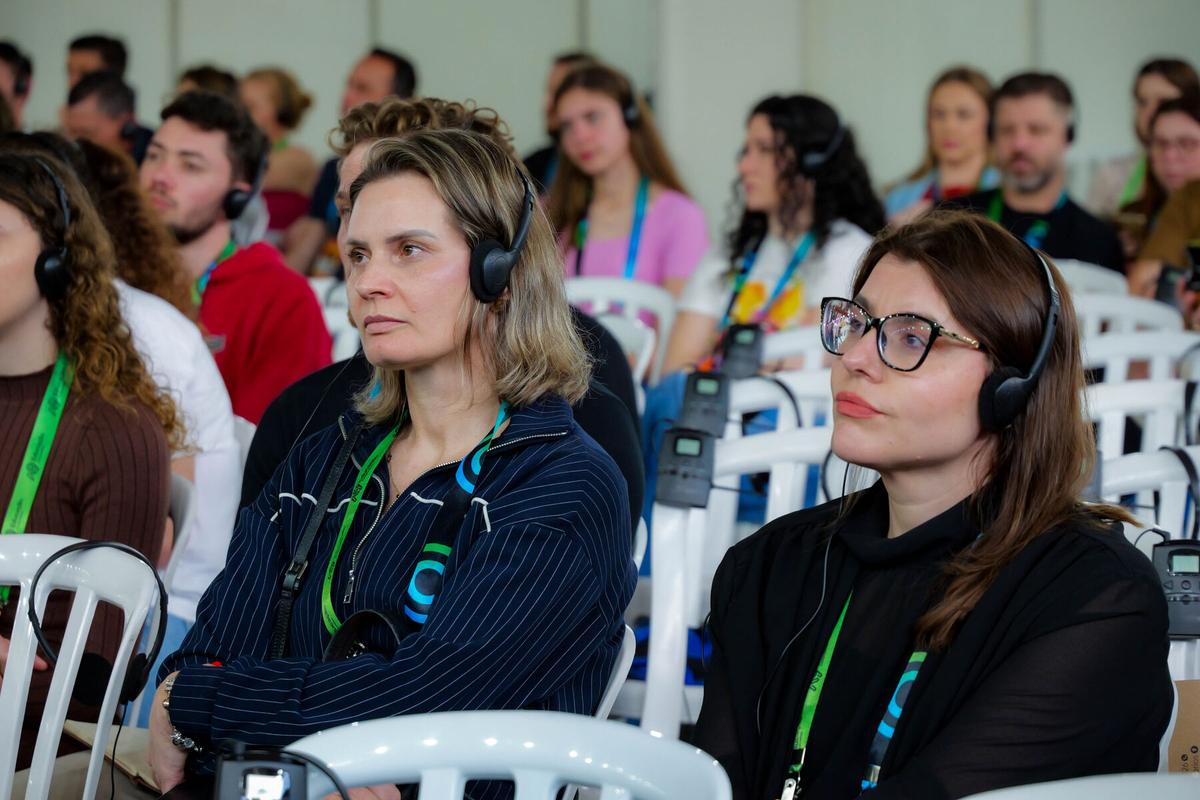 Duas mulheres na plateia, atentas à palestra